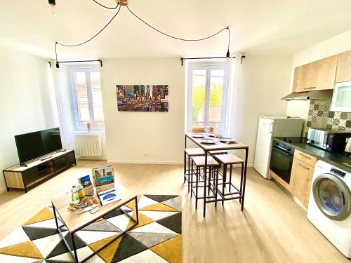 une cuisine et un salon avec une table et des chaises dans l'établissement L'Arlequin, cosy et calme, à Limoges