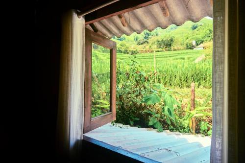 an open window with a view of a field at Sa Moc - La Maison House & Bungalow in Sa Pa