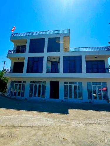 a white building with windows and a blue sky at Veranda White House in Batumi