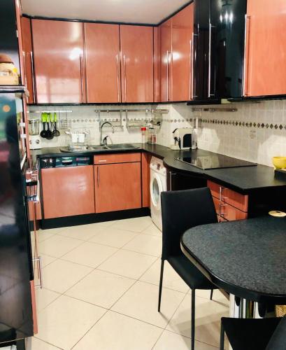 une cuisine avec des placards en bois et une table avec une table dans l'établissement Appartement Cosy, à Menton