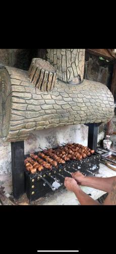 a person is cooking food on a grill at Veranda White House in Batumi