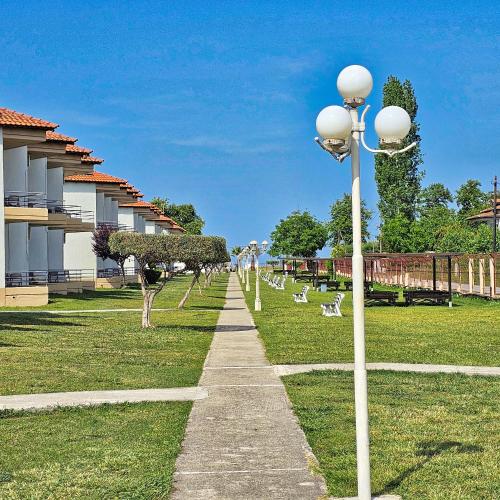 a pathway in a park with a row of lights at Olympion Melathron Villas in Platamonas