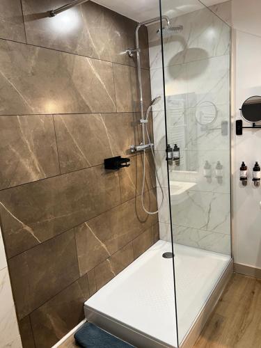 une salle de bain avec une douche avec une porte vitrée dans l'établissement L'Intemporel, à Saint-Cyr-sur-Mer