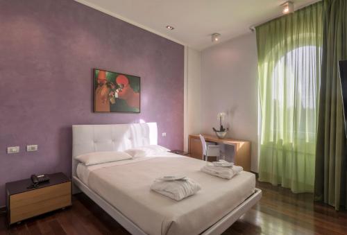 a bedroom with a large white bed and a window at Arthotel & Park Lecce in Lecce