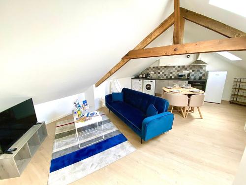 un salon avec un canapé bleu et une table dans l'établissement Le Ronsard, intime et spacieux, à Limoges