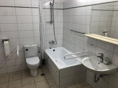 a white bathroom with a toilet and a sink at Apartamenty JN Poznań Rzeczna 4 in Poznań