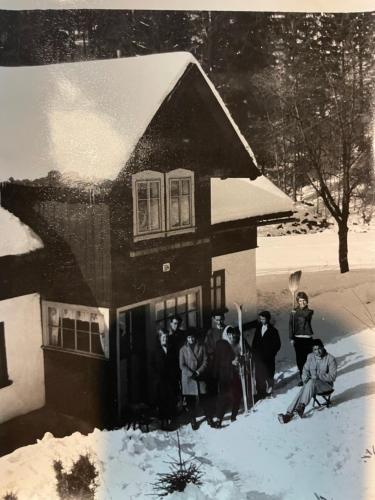 a group of people standing outside of a house in the snow at Chalupa U Horníků in Vítkovice