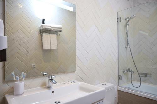 a bathroom with a sink and a shower and a mirror at Meridian in Karagandy