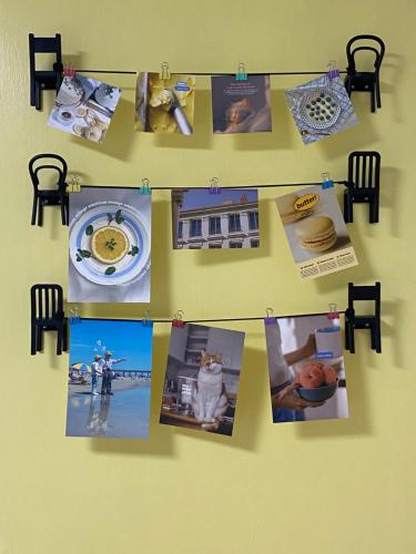a bunch of pictures are hanging on a wall at Haekong's House in Seoul