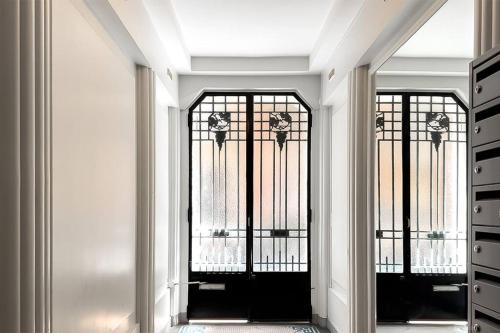 un couloir avec des portes en fer forgé dans un bâtiment dans l'établissement TWIN 1 & 2 - Studio-Métro Paris Disneyland-WIFI-RER A, à Vincennes