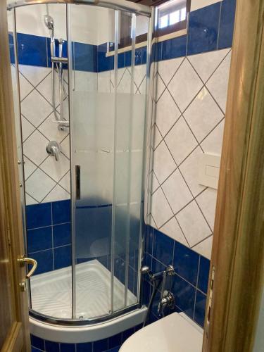 a bathroom with a shower with blue and white tiles at SIMPLY INN close to TIVOLI in Marcellina