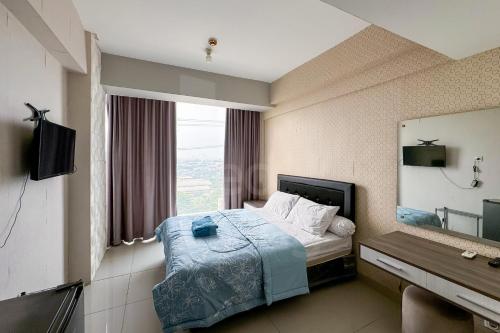 a hotel room with a bed and a large window at RedLiving Apartemen Majestic Point Serpong by Lucia in Tangerang