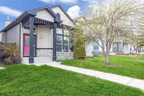 a house with a red door and a green yard at 12 Spacious Home W Ac, Crib, Garage, By Airport in Calgary