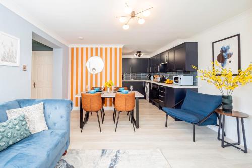 a living room with a blue couch and a kitchen at Air Maison - Bright & Breezy in Portsmouth