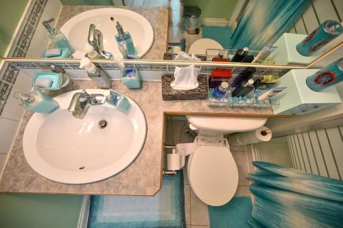 a bathroom with a sink and a toilet and mirrors at 48a Luxury Lake Home W Massage Meditation Gym Ac in Calgary