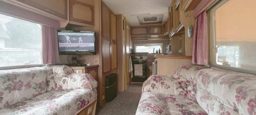 a living room with two chairs and a tv in an rv at Kemping Pod Babią Górą in Zawoja
