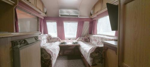 a small living room with couches and a window at Kemping Pod Babią Górą in Zawoja