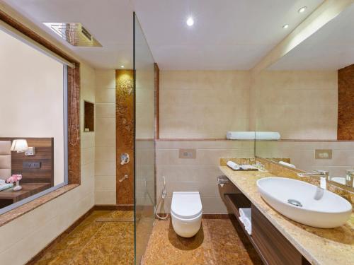 a bathroom with a sink and a toilet and a shower at Tropical Retreat By Zuper in Igatpuri