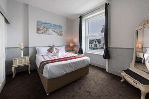 a bedroom with a large bed and a window at The Manor Hotel in Llandudno