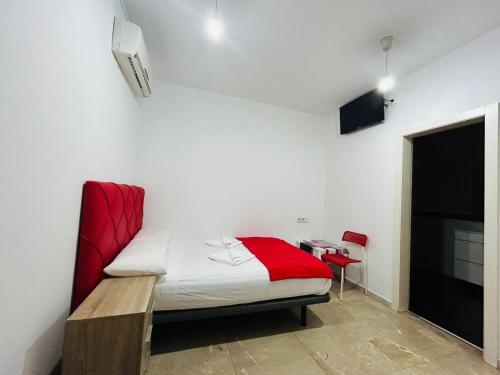 a bedroom with a bed with a red blanket at Hostal Granvia 628 in Barcelona