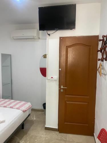 a room with a door and a television on the wall at Hostal Granvia 628 in Barcelona