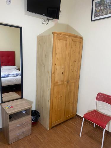 a bedroom with a wooden cabinet and a mirror at Hostal Granvia 628 in Barcelona