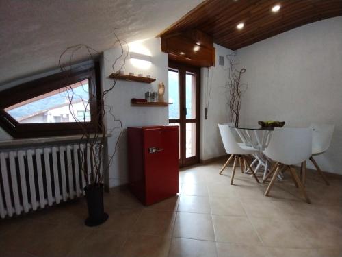 a room with a red refrigerator and a table and chairs at Vinadio Sole & Relax in Vinadio