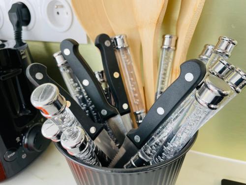 a metal container filled with knives and wine glasses at Les Remparts, 5min du ZooParc in Saint-Aignan