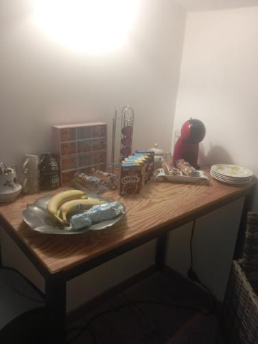 une table en bois avec deux bananes dessus dans l'établissement Chambre delking-size & piscine & Spa & Plage, à Valras-Plage