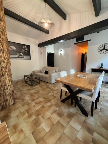 un salon avec une table en bois et un canapé dans l'établissement L'atelier cosy!, à Laroque