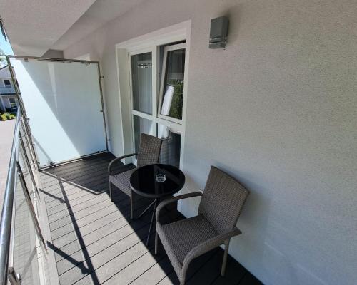 a balcony with two chairs and a table and a window at Srebrna Wydma Resort in Dąbki