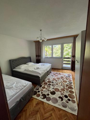 a bedroom with two beds and a rug at Big City House in Bihać