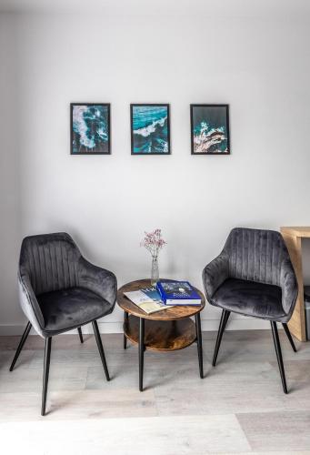 two chairs and a coffee table in a room at Srebrna Wydma Resort in Dąbki