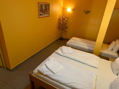 two beds in a room with yellow walls at Esprit Hotel in Budapest