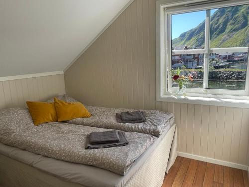a bed with two pillows in a room with a window at Modern Fishermans Cabin in Ballstad