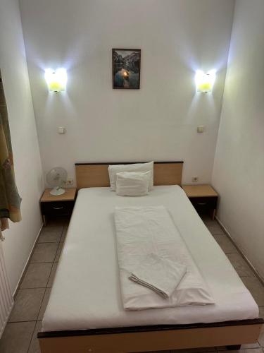 a bed in a room with two lights on the wall at Esprit Hotel in Budapest
