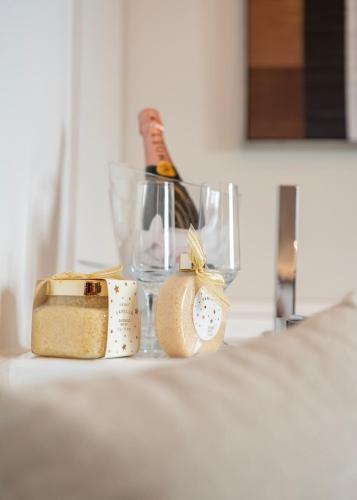 a bottle of champagne in a glass on a bed at Derouse Eva Suite Jacuzzi & Sauna in Athens