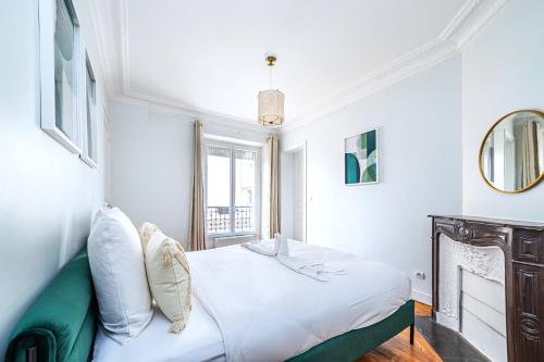 une chambre blanche avec un lit et une fenêtre dans l'établissement Blue and pink flat next Montparnasse, à Paris