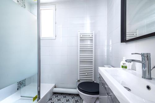 une salle de bain blanche avec des toilettes et un lavabo dans l'établissement Blue and pink flat next Montparnasse, à Paris