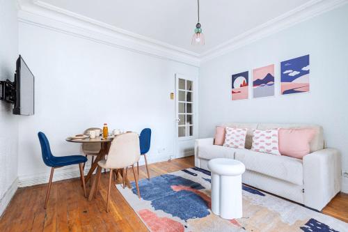 un salon avec un canapé et une table dans l'établissement Blue and pink flat next Montparnasse, à Paris