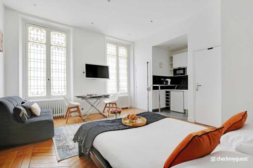 une chambre avec un grand lit et un salon dans l'établissement Charming studio - 3P - Le Marais, à Paris
