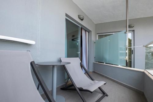 a room with a table and chairs and a window at ARTIEM Audax - Adults Only in Cala Galdana