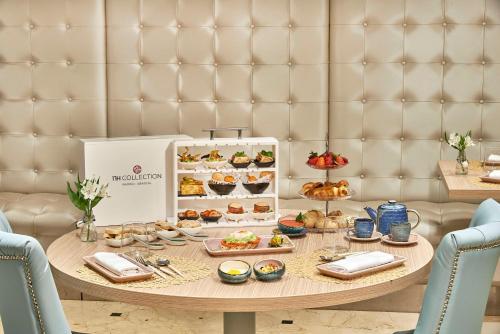 a table with plates of food on top at NH Collection Madrid Abascal in Madrid