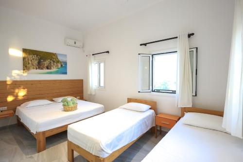 a bedroom with two beds and a window at Casablanca Rooms Dhërmi in Dhërmi