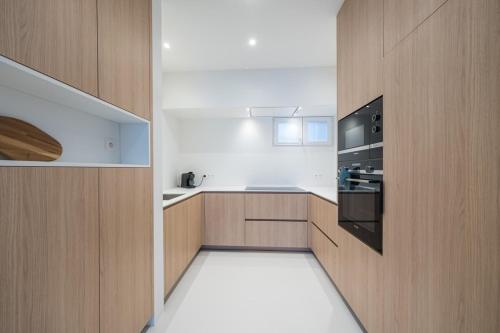 a kitchen with wooden cabinets and a stove top oven at Amandine - Luxury 3 bedrooms apartment with free parking in Ostend