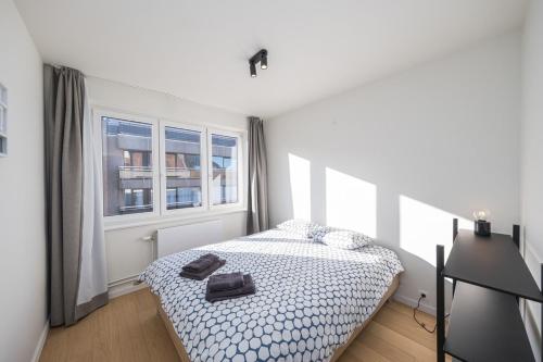 a white bedroom with a bed and a window at Amandine - Luxury 3 bedrooms apartment with free parking in Ostend