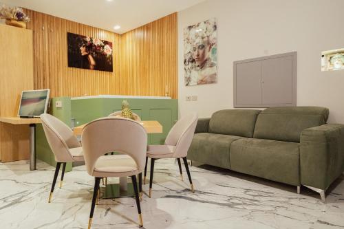 a living room with a couch and a table and chairs at Ortigia Sitari suites in Siracusa
