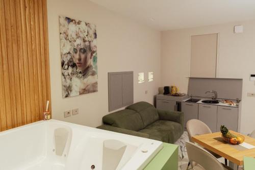 a living room with a couch and a kitchen at Ortigia Sitari suites in Siracusa