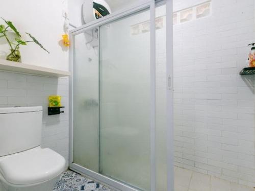 a bathroom with a toilet and a glass shower at Stylish Villa at Green Apple U 35A Cipanas Puncak in Sindanglaya