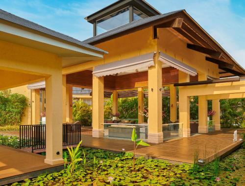 a house with a large deck with a pond at Tropical Retreat By Zuper in Igatpuri